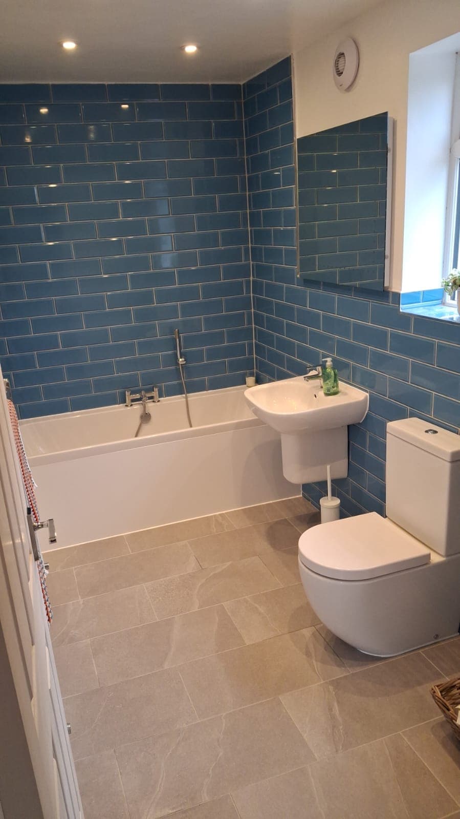 Blue tiled bathroom refurbishment in Caterham by HOC Home Improvements
